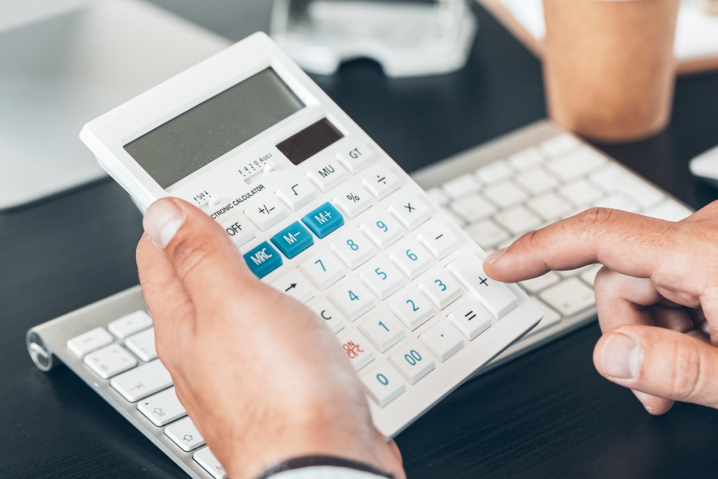 Close up of a businessman using calculator in office